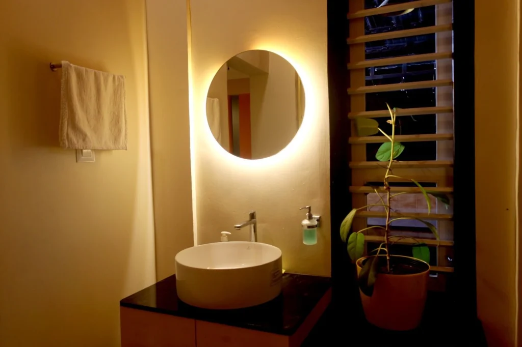 Wash basin with a round lit mirror
