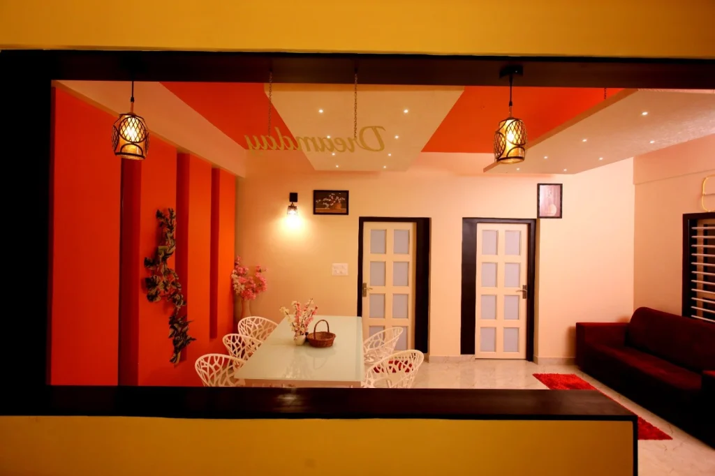 Dining table with pendant lights and the orange feature wall