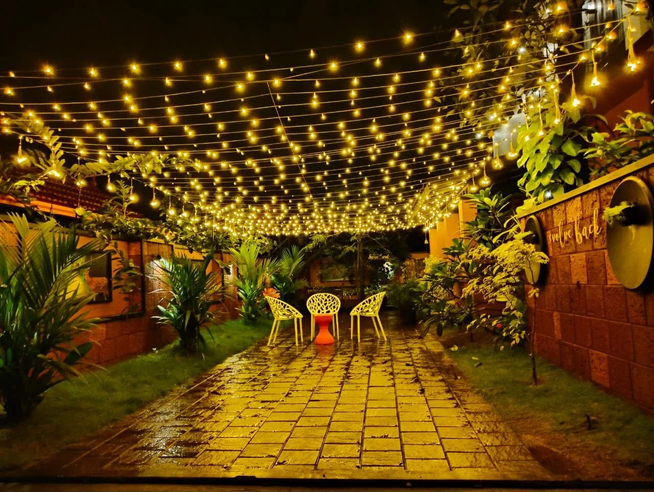 The garden patio at night under strings of fairy lights