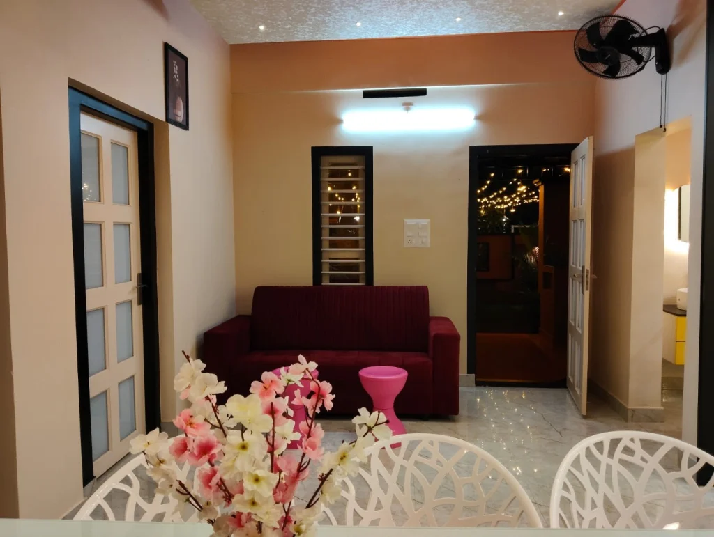 Living room with a red sofa, seen from the dining table