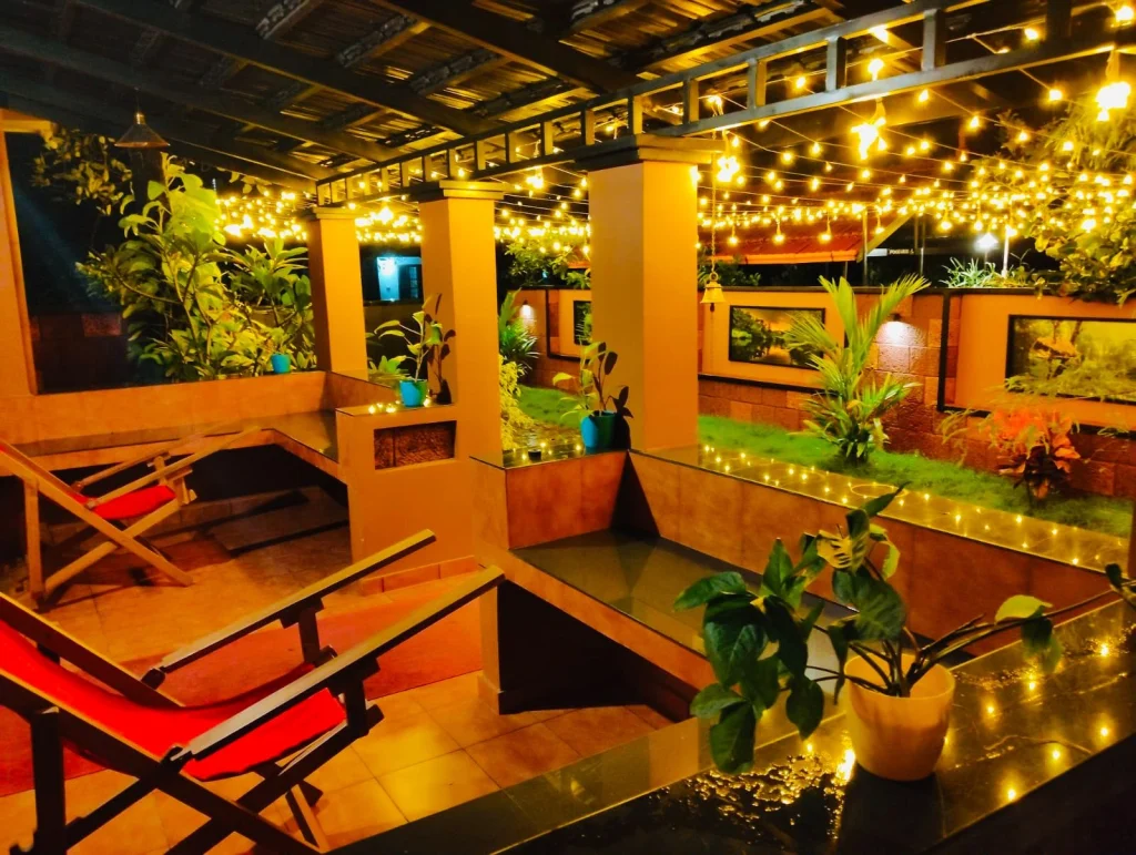 The covered sit-out with easy chairs, lit with fairy lights at night